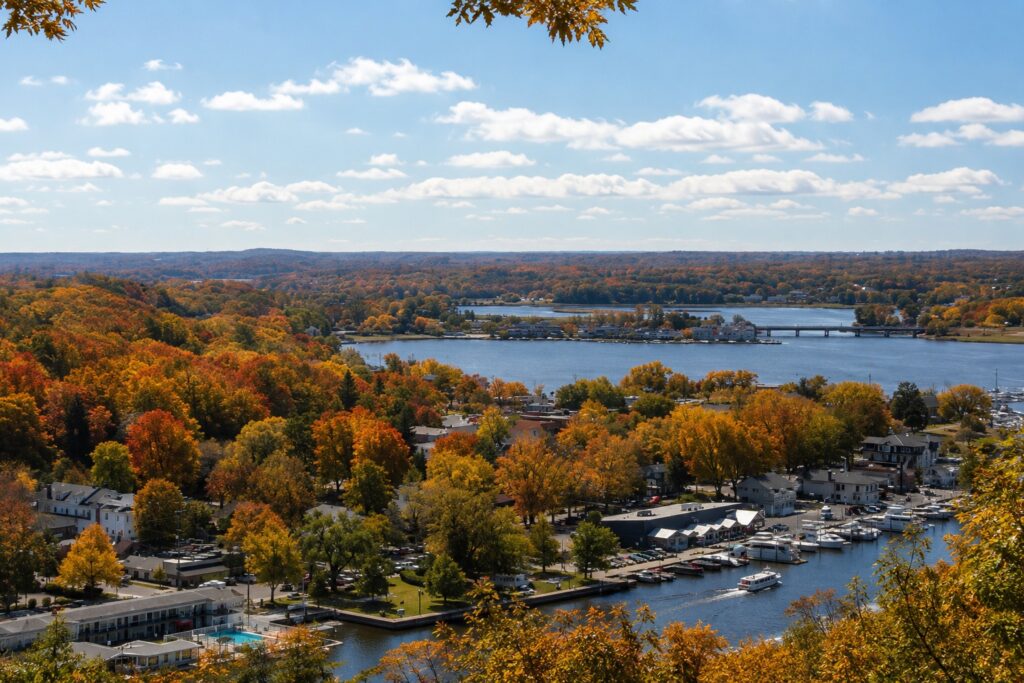 Fall view overlooking downtown Saugatuck, the Kalamazoo River, marina, and colorful autumn foliage from Mount Baldhead in Michigan.