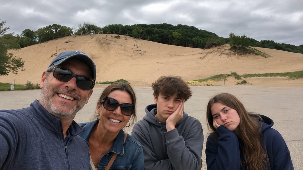 Family taking a selfie in front of the sand dunes at Warren Dunes State Park in Southwest Michigan.